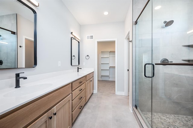 bathroom featuring vanity, tile patterned floors, and walk in shower