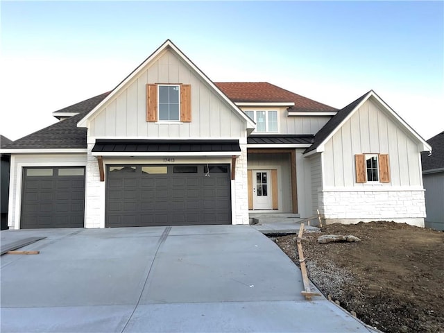 modern farmhouse style home featuring driveway, a standing seam roof, board and batten siding, and roof with shingles