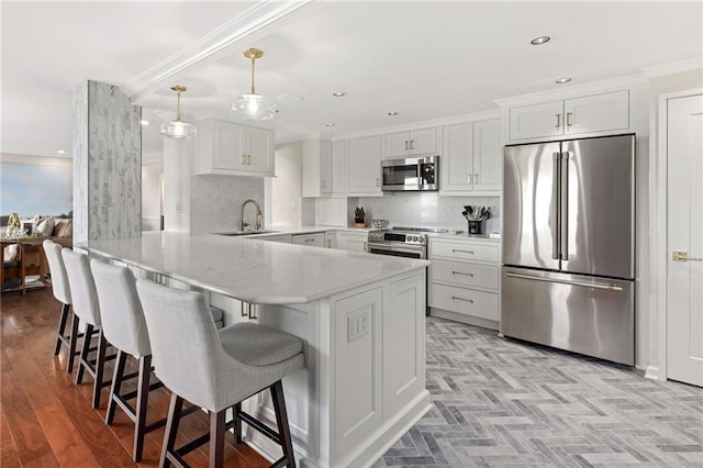 kitchen featuring kitchen peninsula, stainless steel appliances, sink, decorative light fixtures, and white cabinetry