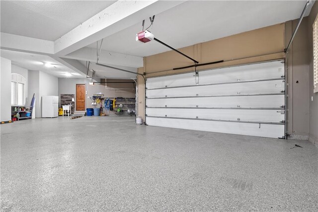 garage with freestanding refrigerator and a garage door opener