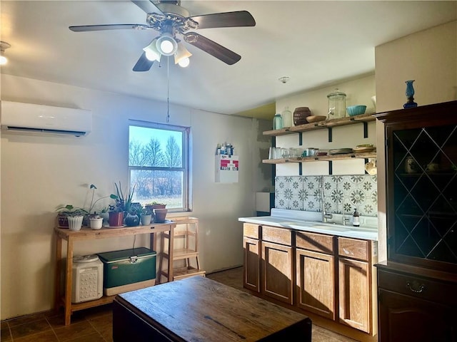 interior space with a sink, a wall mounted AC, a ceiling fan, and dark tile patterned flooring