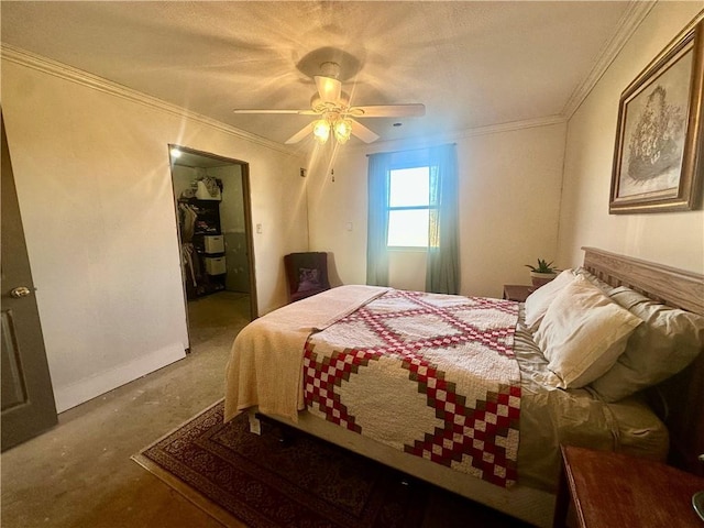 bedroom featuring a spacious closet, baseboards, ornamental molding, carpet flooring, and a ceiling fan