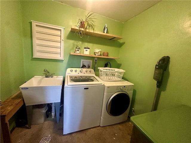 laundry room featuring washing machine and clothes dryer, laundry area, and a sink