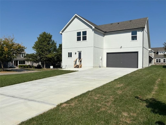 view of front of property featuring a front lawn and a garage