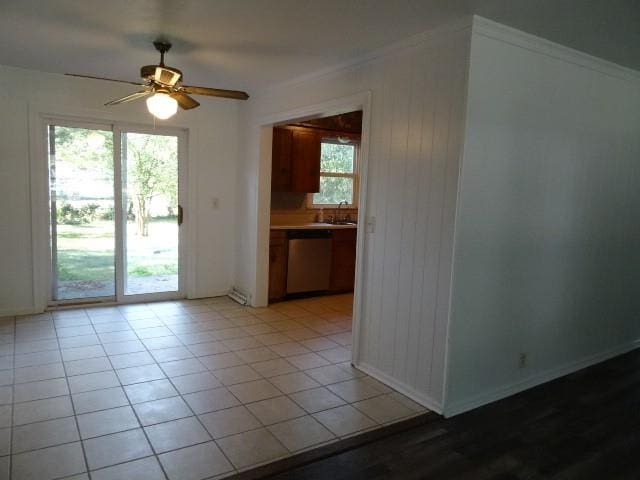 tiled spare room featuring crown molding, sink, and ceiling fan