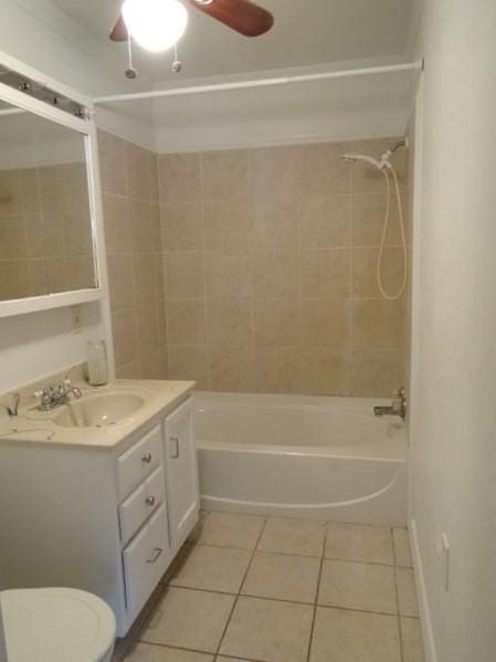 full bathroom with tiled shower / bath, tile patterned floors, toilet, ceiling fan, and vanity