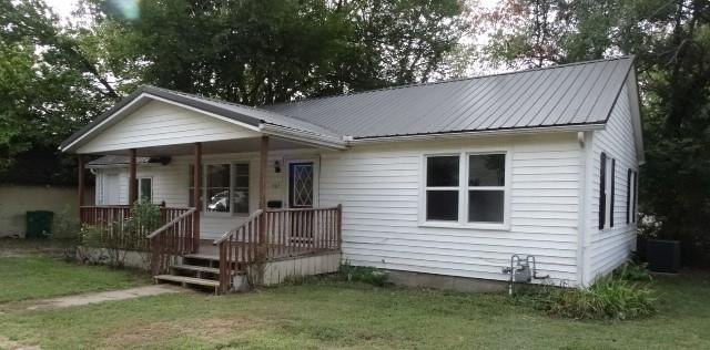 bungalow with cooling unit, a front lawn, and a porch