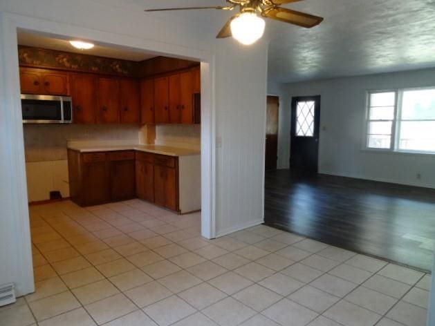 kitchen featuring ceiling fan, decorative backsplash, and light hardwood / wood-style floors