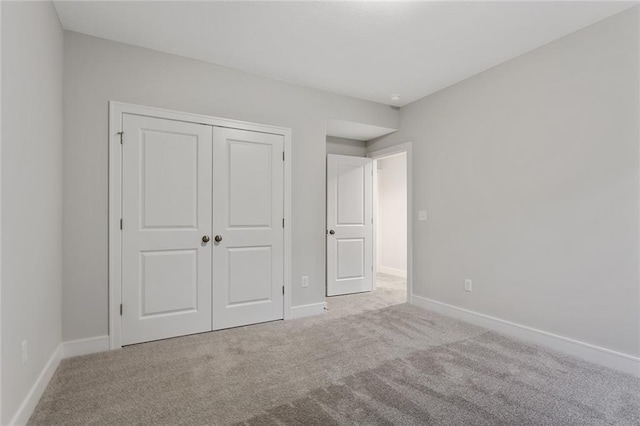 unfurnished bedroom featuring light carpet and a closet