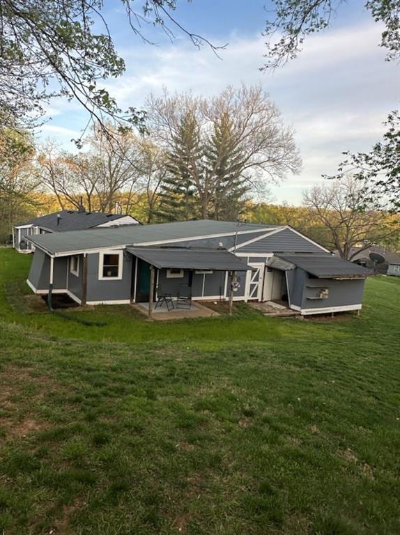 rear view of property featuring a patio and a lawn