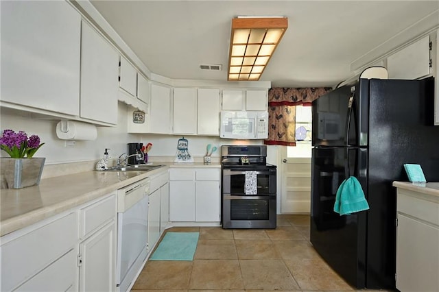 kitchen with white cabinets, white appliances, sink, and light tile floors