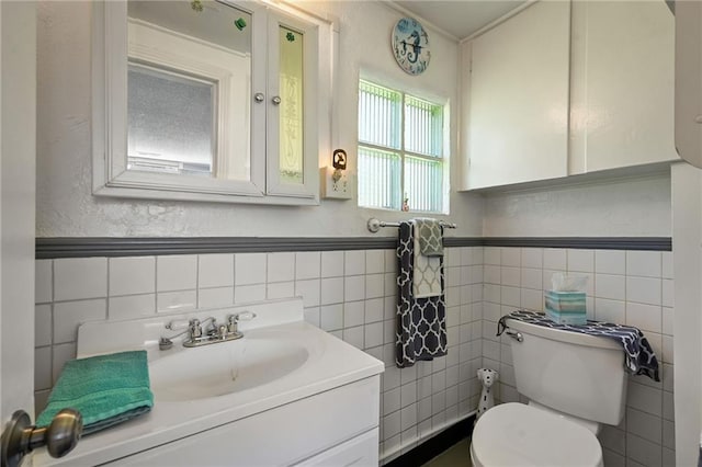 bathroom featuring tile walls, large vanity, and toilet