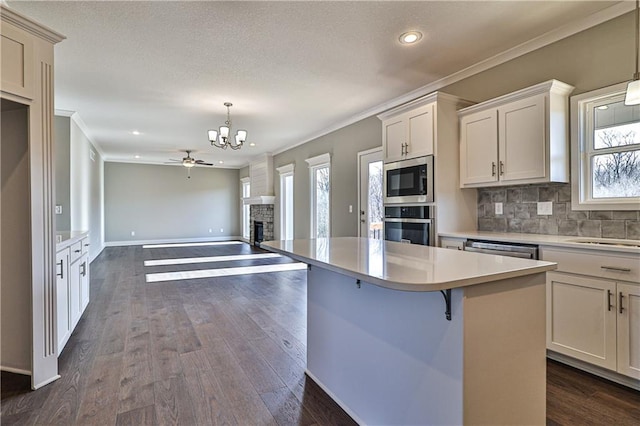 kitchen featuring hanging light fixtures, appliances with stainless steel finishes, ceiling fan, and a healthy amount of sunlight