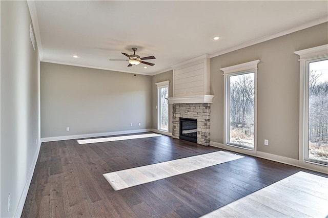 unfurnished living room featuring dark hardwood / wood-style floors, crown molding, a fireplace, and a wealth of natural light