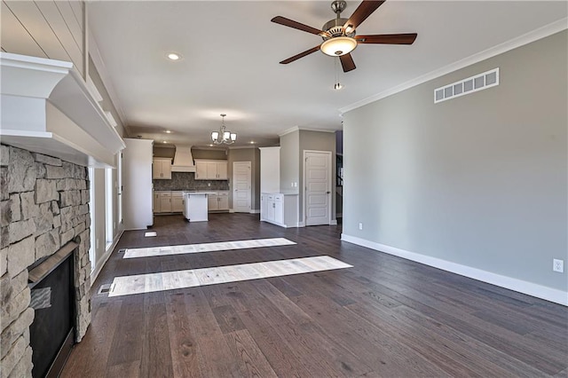 unfurnished living room with a fireplace, dark hardwood / wood-style flooring, ceiling fan with notable chandelier, and crown molding