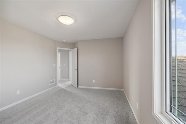 carpeted spare room featuring a healthy amount of sunlight