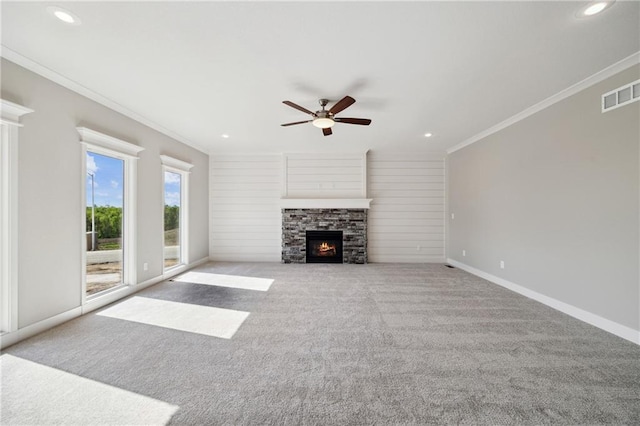 unfurnished living room featuring ceiling fan, light colored carpet, ornamental molding, and a fireplace