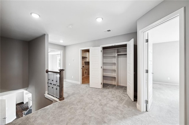 unfurnished bedroom with light colored carpet and a closet