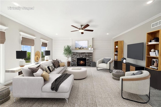 carpeted living room featuring a fireplace, ceiling fan, and crown molding