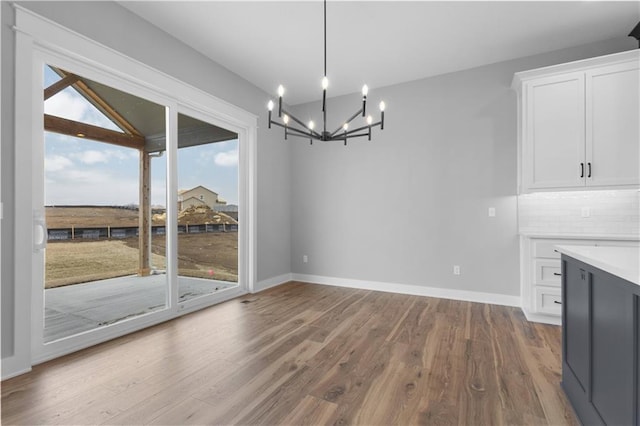 unfurnished dining area featuring hardwood / wood-style flooring and a notable chandelier