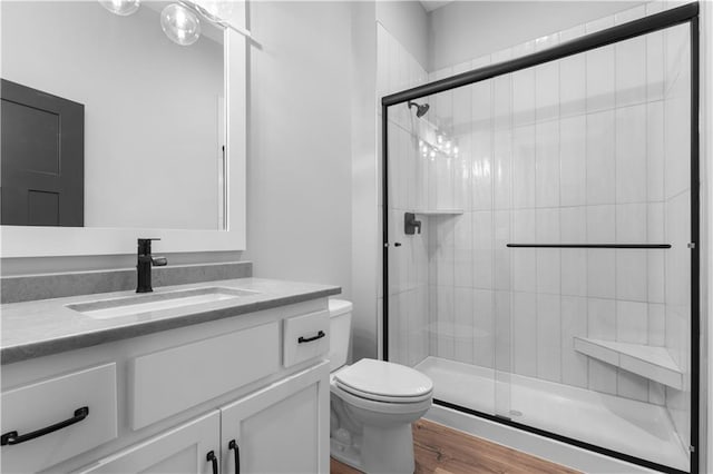 bathroom featuring walk in shower, vanity, toilet, and hardwood / wood-style flooring