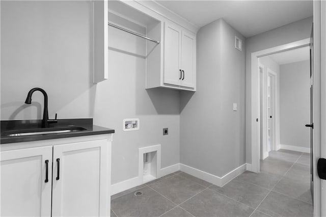 clothes washing area with sink, cabinets, tile patterned flooring, washer hookup, and hookup for an electric dryer