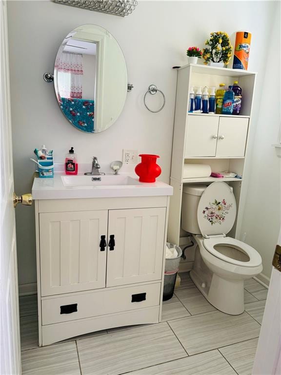 bathroom with tile floors, vanity, and toilet