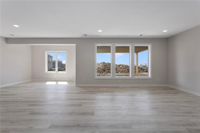 unfurnished room featuring baseboards, light wood-style flooring, and recessed lighting