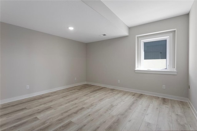 empty room with light wood finished floors, recessed lighting, visible vents, and baseboards