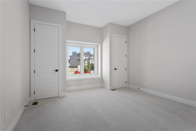 carpeted empty room with baseboards