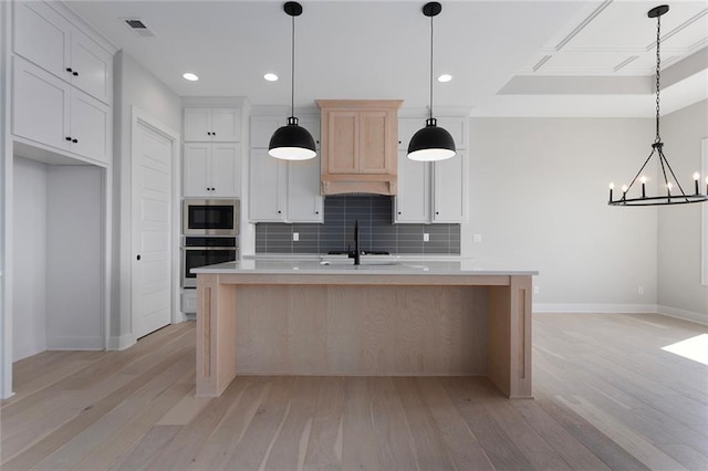 kitchen featuring visible vents, light countertops, appliances with stainless steel finishes, light wood-type flooring, and backsplash