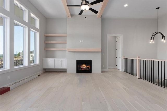 unfurnished living room with beam ceiling, light wood finished floors, a baseboard radiator, a tiled fireplace, and baseboards