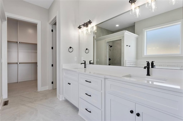 full bathroom featuring visible vents, a sink, a shower stall, and double vanity