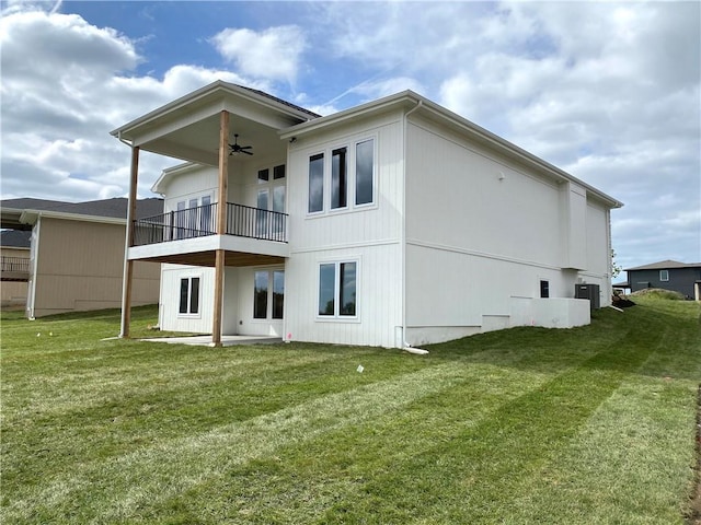 rear view of property featuring a balcony, a yard, cooling unit, and ceiling fan