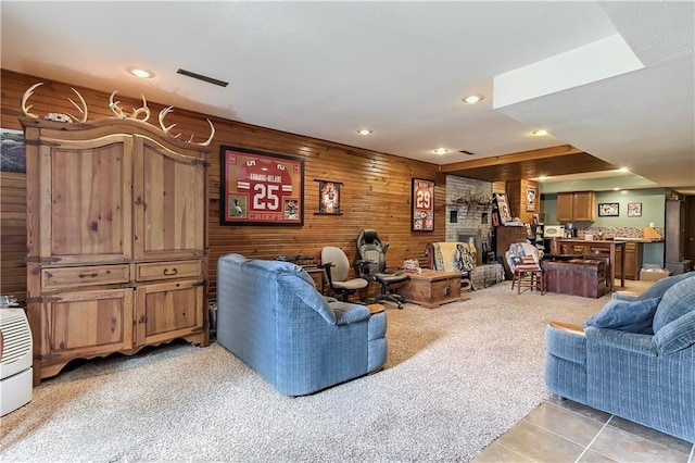 living room with wood walls and light colored carpet