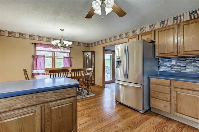 kitchen with ceiling fan with notable chandelier, hanging light fixtures, light hardwood / wood-style floors, and stainless steel fridge with ice dispenser