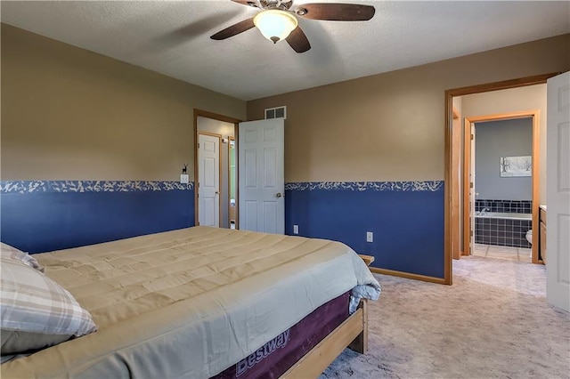 bedroom featuring a textured ceiling, carpet, connected bathroom, and ceiling fan