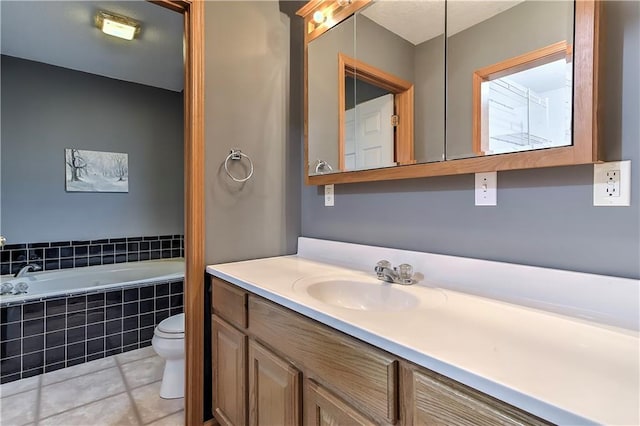 bathroom with vanity, toilet, tile patterned floors, and a relaxing tiled tub