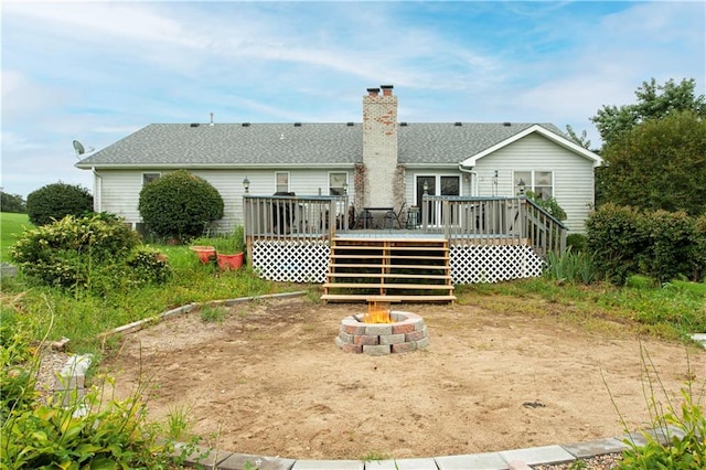 rear view of property featuring a wooden deck and an outdoor fire pit