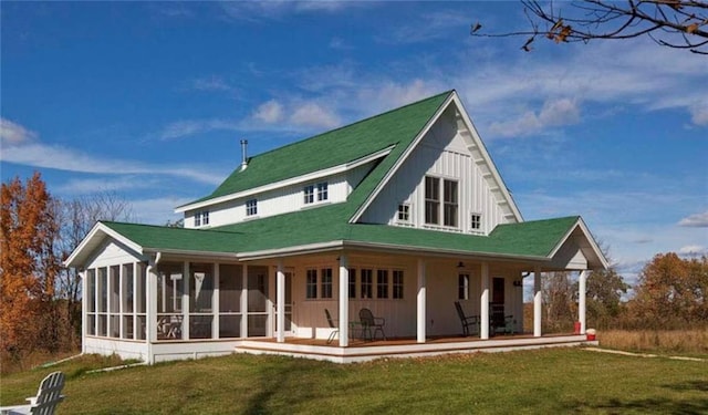 back of house featuring a sunroom and a lawn