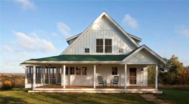 rear view of property featuring a yard and covered porch