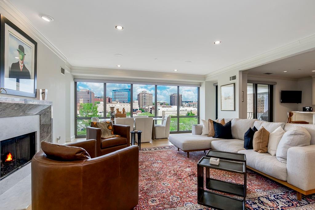 433 Ward Pkwy Unit 2N, Kansas City, MO 64112 - living room with a healthy amount of sunlight, ornamental molding, and a premium fireplace