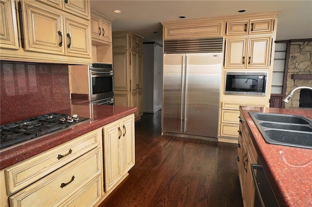 kitchen with dark hardwood / wood-style floors, sink, decorative backsplash, black appliances, and cream cabinets