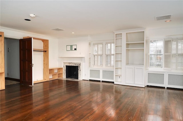 unfurnished living room featuring crown molding, a high end fireplace, dark hardwood / wood-style flooring, and radiator heating unit