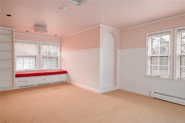 empty room with light carpet, a wealth of natural light, ornamental molding, and baseboard heating