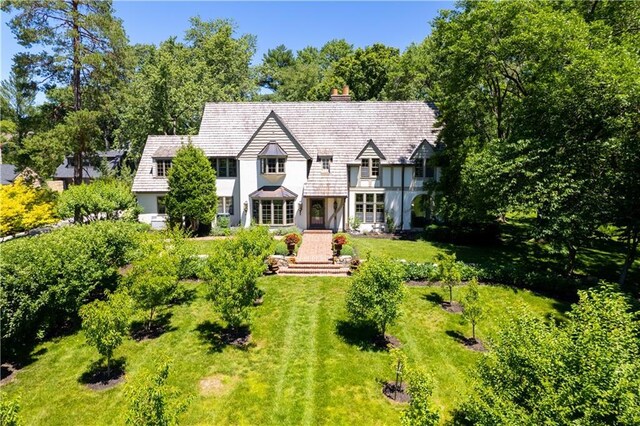3700 W 65th St, Mission Hills, KS 66208 - tudor home with stucco siding, a front yard, a chimney, and view of scattered trees