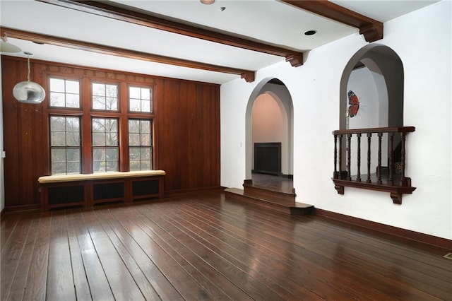 3700 W 65th St, Mission Hills, KS 66208 - unfurnished living room with beam ceiling, hardwood / wood-style flooring, a fireplace, and arched walkways