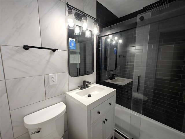 bathroom featuring a shower with door, tile walls, toilet, and vanity