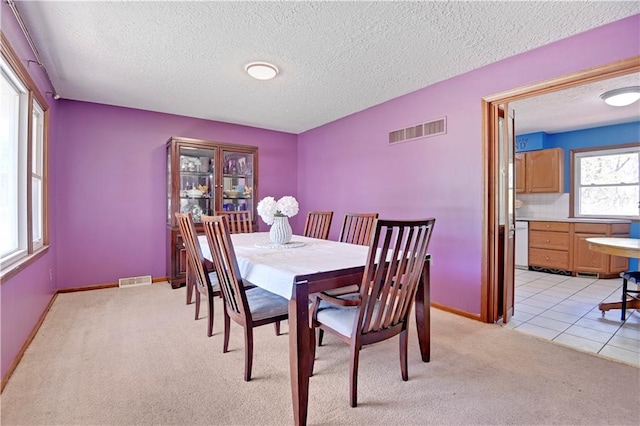 tiled dining room with a textured ceiling