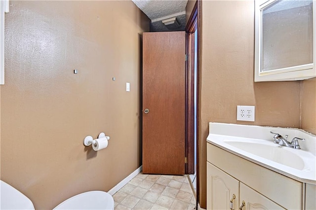 bathroom featuring tile floors, oversized vanity, toilet, and a textured ceiling